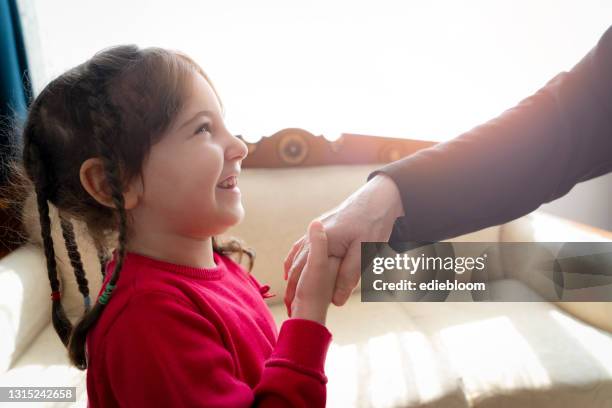little girl kissing grandmather hand at religious festival - kissing hand stock pictures, royalty-free photos & images