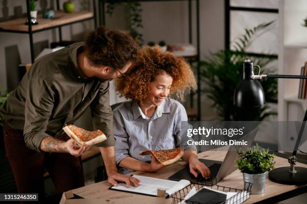 hungry coworkers having lunch break at the office stock photo - milos dimic stock pictures, royalty-free photos & images