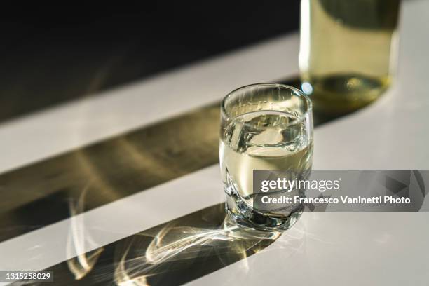 glass and bottle with hard liquor. - vodka stock-fotos und bilder