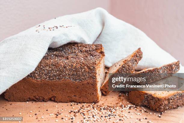 homemade amaranthus and quinoa loaf and slices of bread. - quinoa stockfoto's en -beelden
