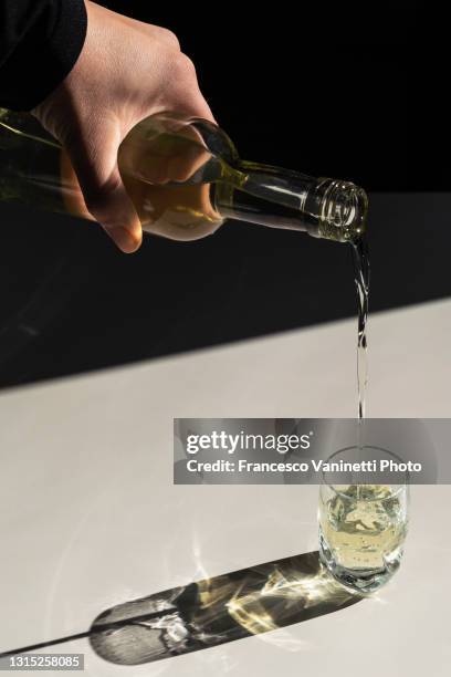 hand pouring some hard liquor in a glass. - vodka stock pictures, royalty-free photos & images