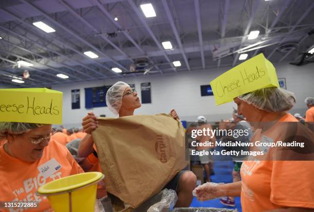 Clayton Rubright of Womelsdorf fills the Soy Flour bin during the United Way of Berks County's Big Cheese II Saturday at Penn State Berks. Women in...