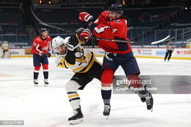 Brenden Dillon of the Washington Capitals checks Colton Sceviour of the Pittsburgh Penguins during the first period at Capital One Arena on April 29,...