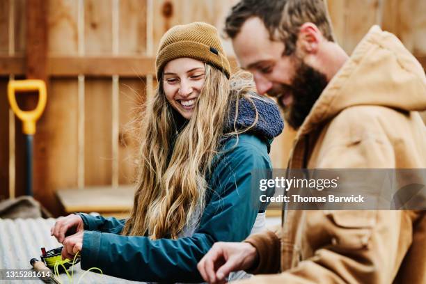 medium shot of smiling couple preparing fly roads before going fishing on winter afternoon - thomas teal stock pictures, royalty-free photos & images