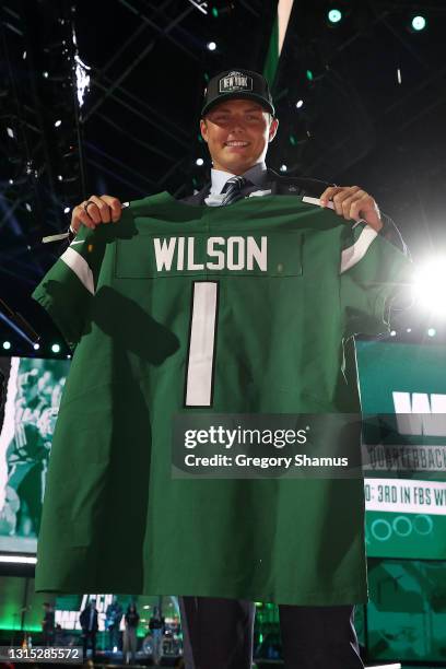 Zach Wilson holds a jersey onstage after being drafted second by the New York Jets during round one of the 2021 NFL Draft at the Great Lakes Science...