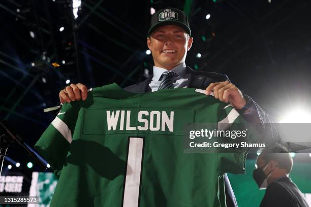 Zach Wilson holds a jersey onstage after being drafted second by the New York Jets during round one of the 2021 NFL Draft at the Great Lakes Science...