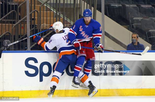 Nick Leddy of the New York Islanders checks Alexis Lafreniere of the New York Rangers during the second period at Madison Square Garden on April 29,...