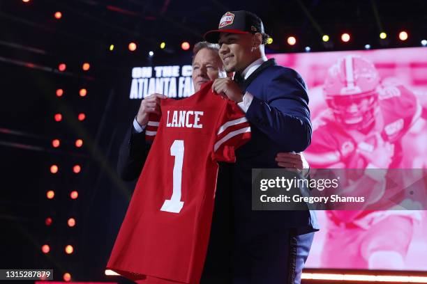 Trey Lance poses with NFL Commissioner Roger Goodell onstage after being selected third by the San Francisco 49ers during round one of the 2021 NFL...