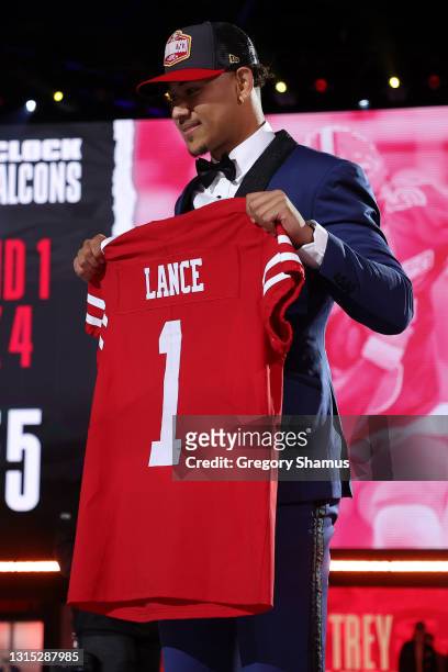 Trey Lance poses with a jersey onstage after being selected third by the San Francisco 49ers during round one of the 2021 NFL Draft at the Great...