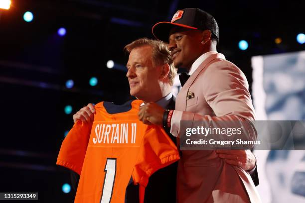 Patrick Surtain II poses with NFL Commissioner Roger Goodell onstage after being selected ninth by the Denver Broncos during round one of the 2021...