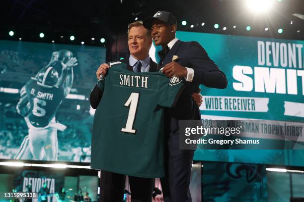 DeVonta Smith poses with NFL Commissioner Roger Goodell onstage after being selected 10th by the Philadelphia Eagles during round one of the 2021 NFL...