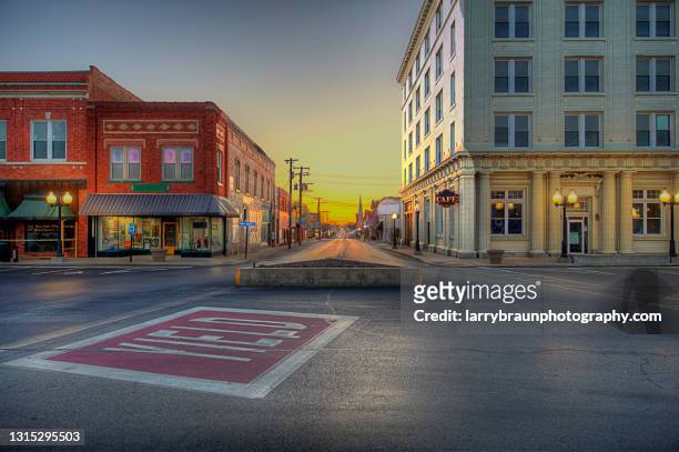 view down main street from town plaza - small town america stock-fotos und bilder