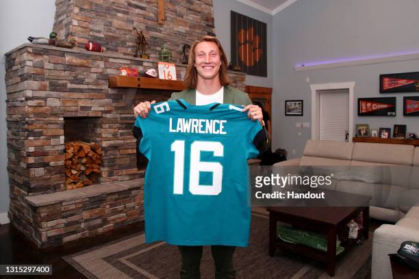 In this handout photo provided by the National Football League, quarterback Trevor Lawrence poses after being selected with the first overall pick by...