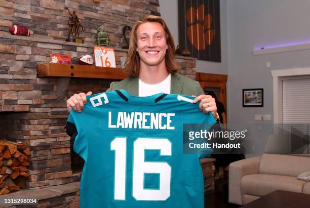 In this handout photo provided by the National Football League, quarterback Trevor Lawrence poses after being selected with the first overall pick by...