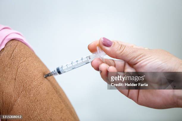 close up of covid-19 vaccine injection - vacinação stockfoto's en -beelden