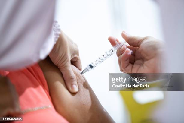 closeup of an elderly woman receiving the covid-19 vaccine - vacinação stockfoto's en -beelden