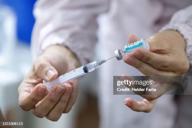 nurse prepares covid-19 vaccine syringe - vacinação stockfoto's en -beelden