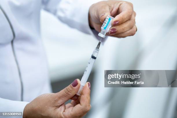 nurse prepares covid-19 vaccine syringe - vacinação stockfoto's en -beelden