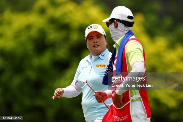 Inbee Park of South Korea speaks to her husband and caddie Gi Hyeob Nam after sinking her putt on the 13th green during the second round of the HSBC...