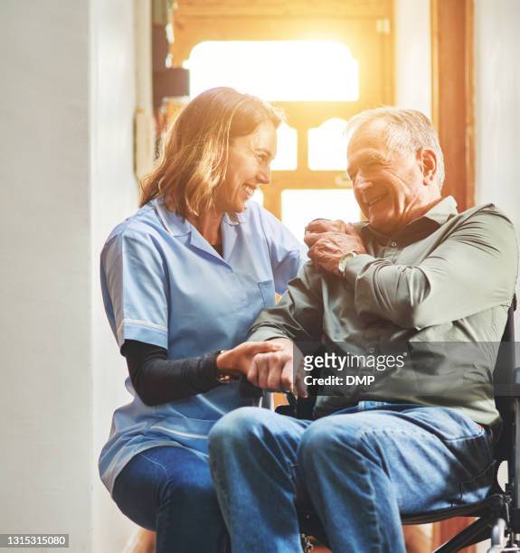 shot of a young nurse caring for a senior man in a wheelchair in a retirement home - staff wellbeing stock pictures, royalty-free photos & images