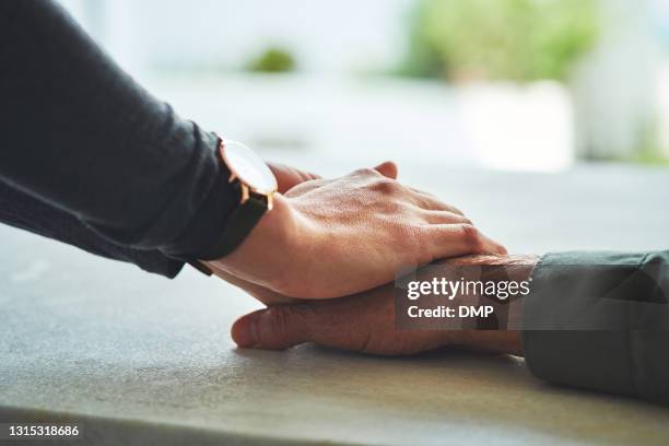 closeup shot of a nurse holding a senior man's hand in comfort - consoling hands stock pictures, royalty-free photos & images