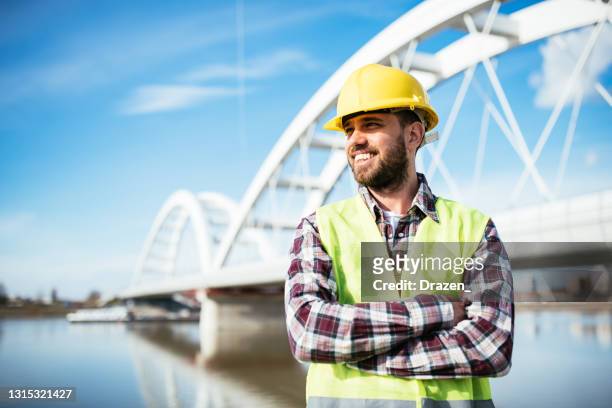 construction engineer with hardhat looking at construction site - serbia bridge stock pictures, royalty-free photos & images