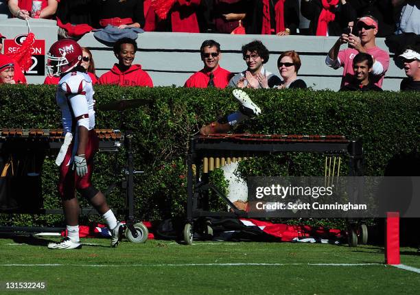 Aron White of the Georgia Bulldogs gets stuck in the hedges after scoring a touchdown against the New Mexico State Aggies at Sanford Stadium on...