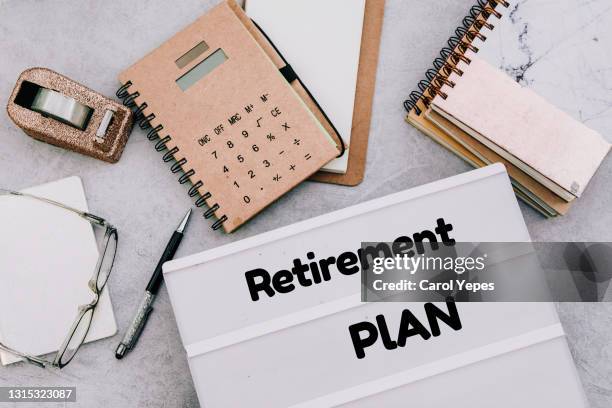 directy above workspace with laptop and office supplies.retirement plan reminder - retirement plan imagens e fotografias de stock