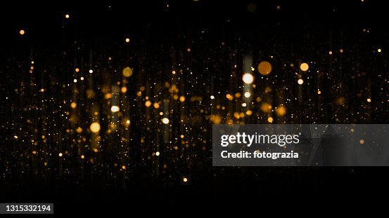 Defocused Golden Particles Glittery against Dark Background with Copy Space. Christmas Overlay Defocused Golden Particles Glittery against Dark Background with Copy Space. Christmas Overlay