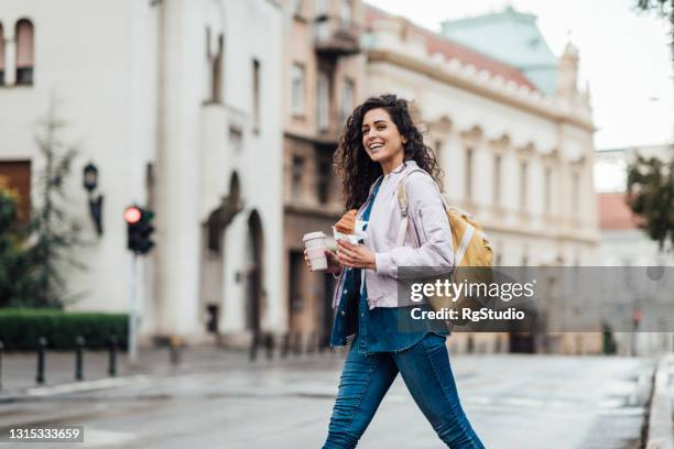 schöne frau mit ihrem frühstück in der stadt - breakfast to go stock-fotos und bilder