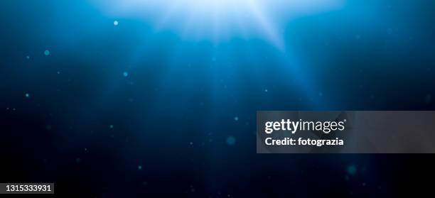 underwater background with sun rays and defocused particles - seabed stock pictures, royalty-free photos & images