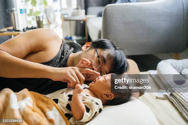 asian single father concern his newborn daughter not sleep and consoling daughter - burping stock-fotos und bilder