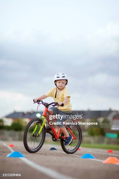 boy in a helmet (4-5 years old) standing on a bicycle in a park-stock photo - bmx freestyle stock pictures, royalty-free photos & images