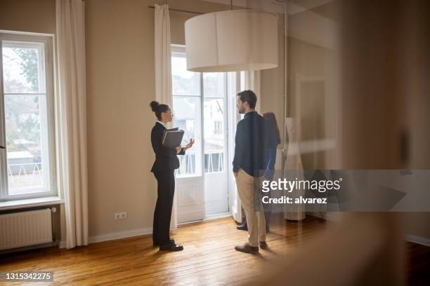 real estate agent selling house to a young couple - agent imagens e fotografias de stock