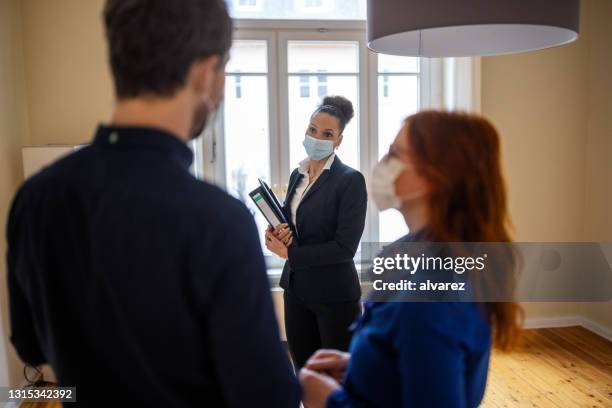 female real estate agent talking to a customer couple - businesswoman mask stock pictures, royalty-free photos & images