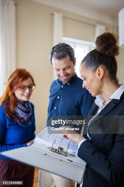 real estate agent and customers discussing over blueprint - floor plan stock pictures, royalty-free photos & images