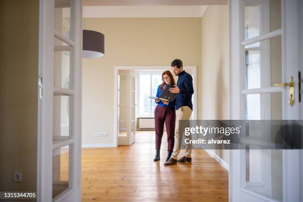 paar dat huisdocumenten analyseert alvorens nieuw huis te kopen - inspection stockfoto's en -beelden