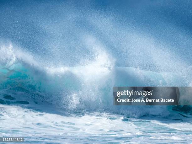 full frame of the crest of a wave of sea with white foam a day of strong gusts of wind. - spray foam stock pictures, royalty-free photos & images