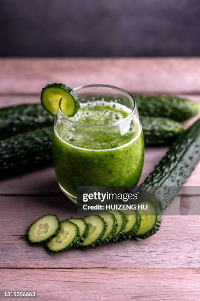 glass of fresh cucumber juice on wooden table - gurke stock-fotos und bilder