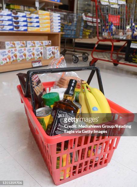 An illustration for the cover of Business Weekly, of a bottle of Jack Daniels Whiskey in a shopping basket at the Redners grocery store in Kenhorst...