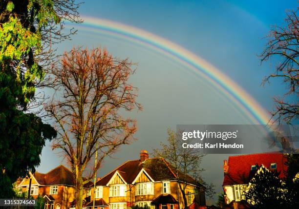 a rainbow over houses on a suburban street - stock photo - barnet stock pictures, royalty-free photos & images