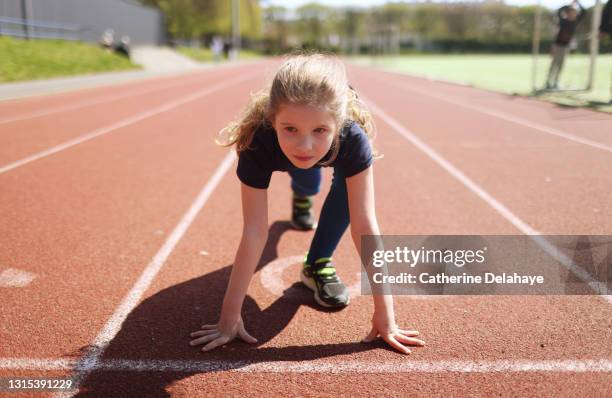 young girl ready to race on an athletics track - fille sport photos et images de collection