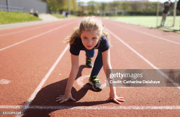 young girl ready to race on an athletics track - pista atletica foto e immagini stock