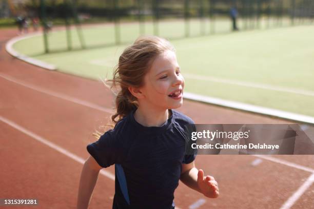 portrait of a young girl racing on an athletics track - physical education stock pictures, royalty-free photos & images