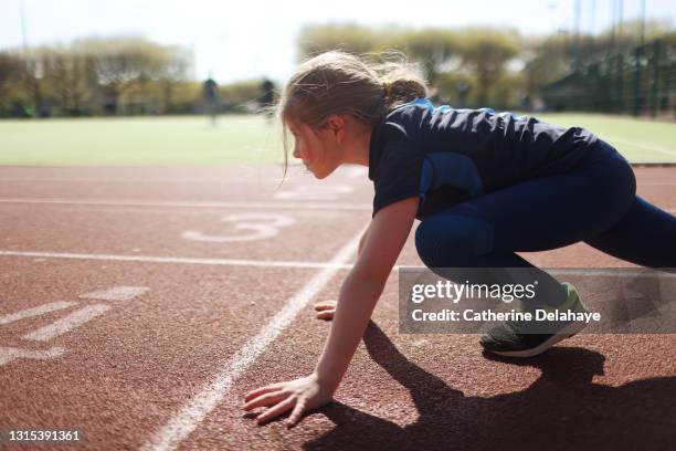 young girl ready to race on an athletics track - pro athlete stock pictures, royalty-free photos & images