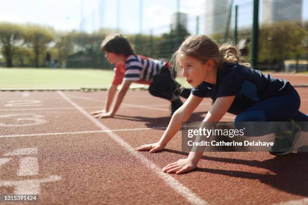 young girl and boy ready to race on an athletics track - race 8 stock pictures, royalty-free photos & images