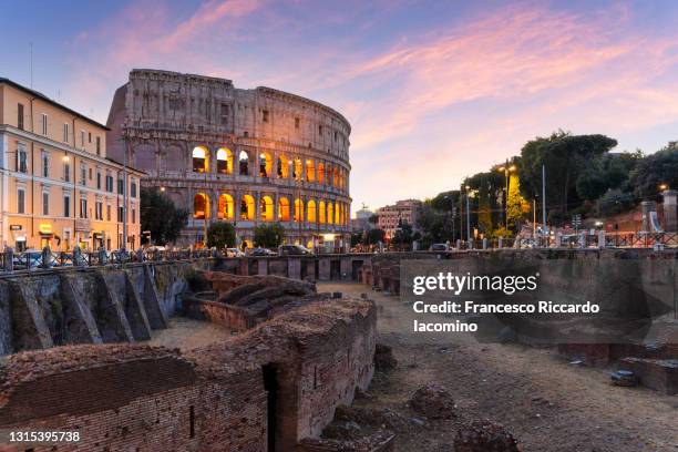 sunset in rome, italy. colosseum and lights on - rome colosseum stock pictures, royalty-free photos & images