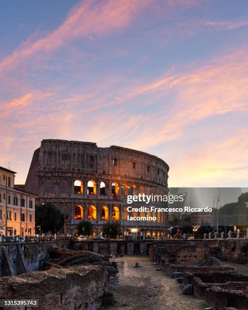 sunset in rome, italy. colosseum and lights on - romeinse rijk stockfoto's en -beelden