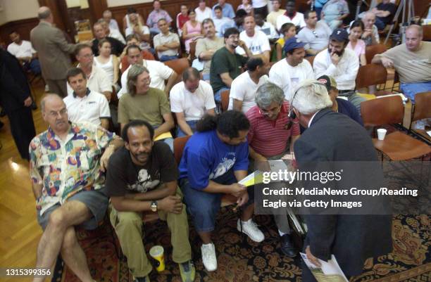 Photo Ryan McFadden 200502209 City property auction in city council chambers; center in blue Ramon Badillo of Reading discusses uping a bid on the...