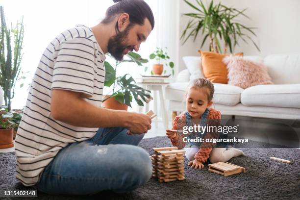 young father and little daughter playing jenga in living room - jenga stock pictures, royalty-free photos & images